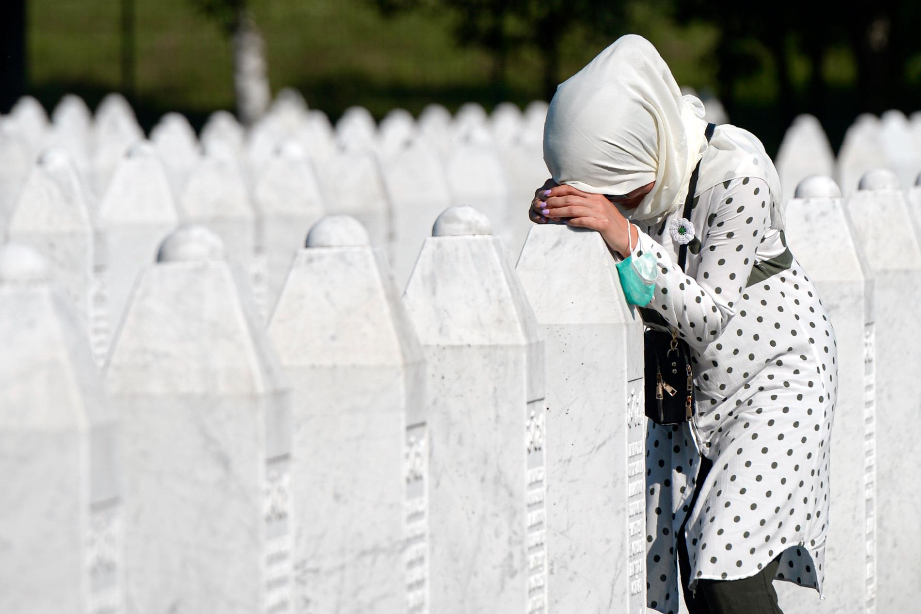 En kvinna sörjer vid en gravsten i Potocari, nära Srebrenica.
