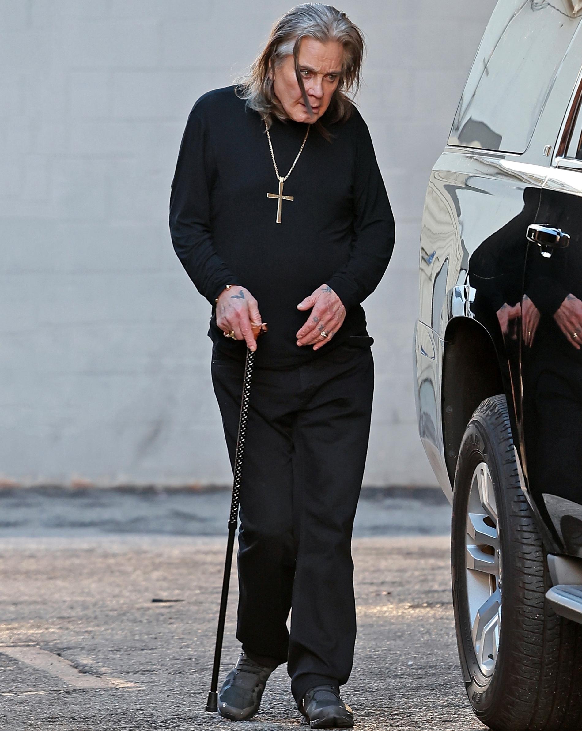 Ozzy Osbourne ute och shoppar med käpp.