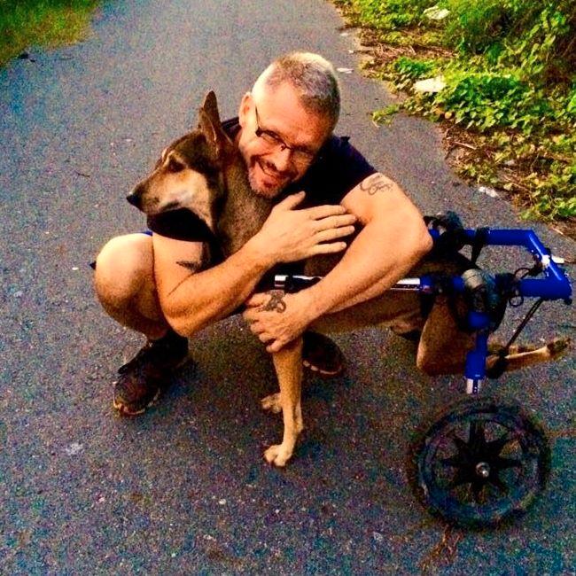 Här är Michael med en av hans egna hundar Coke som han tagit hand om sedan Coke var valp. Coke är förlamad och har därför specialdesignad rullstol.
