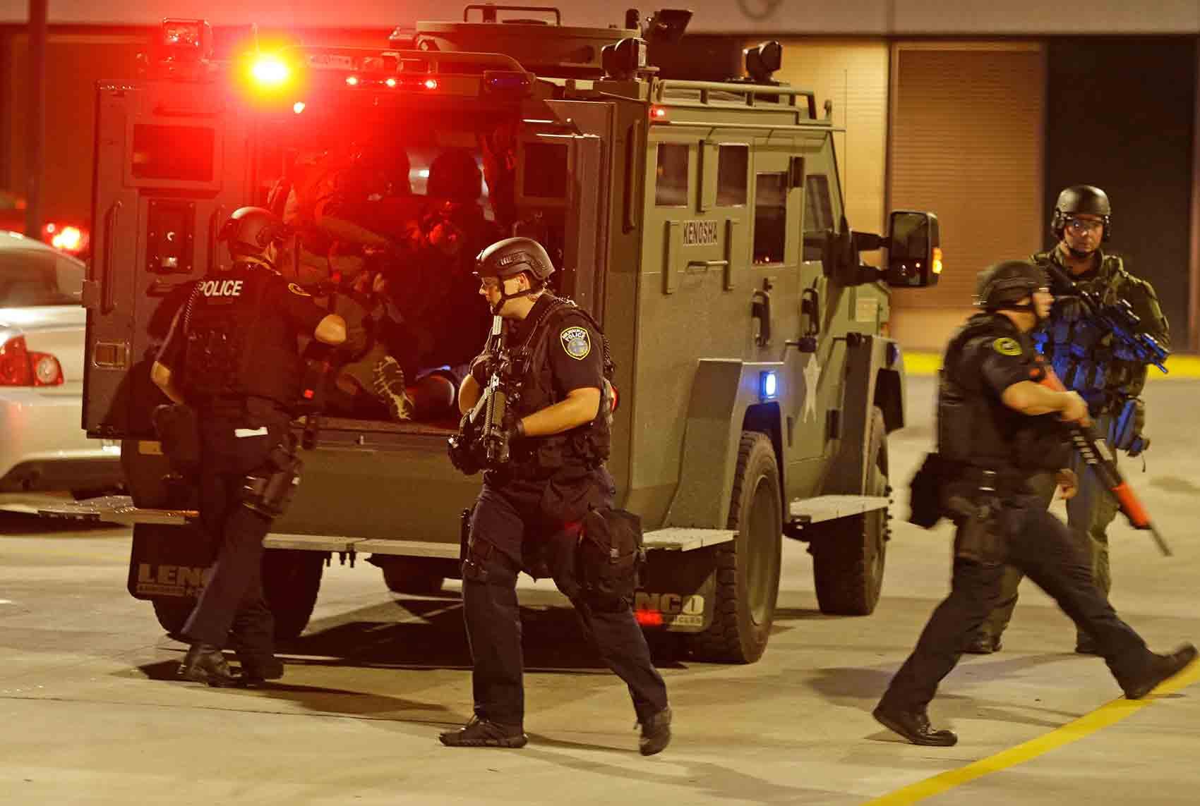 En man som ska ha blivit skottskadad under upploppen i Milwaukee hämtas av polis till sjukhus.