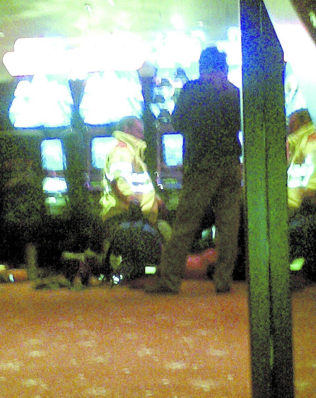 Första hjälpen En av de skottskadade gästerna får första hjälpen av ambulanspersonalen inne på kasinot framför några spelmaskiner.