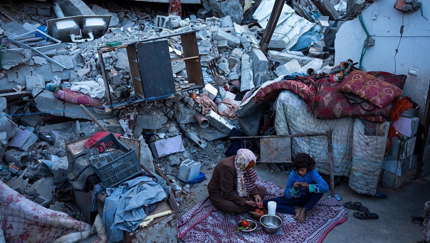 En familj bryter dagens fasta under ramadan, vid resterna av sitt sönderbombade hem i Rafah. I kväll när fastan bryts är ramadan över och Eid firas.