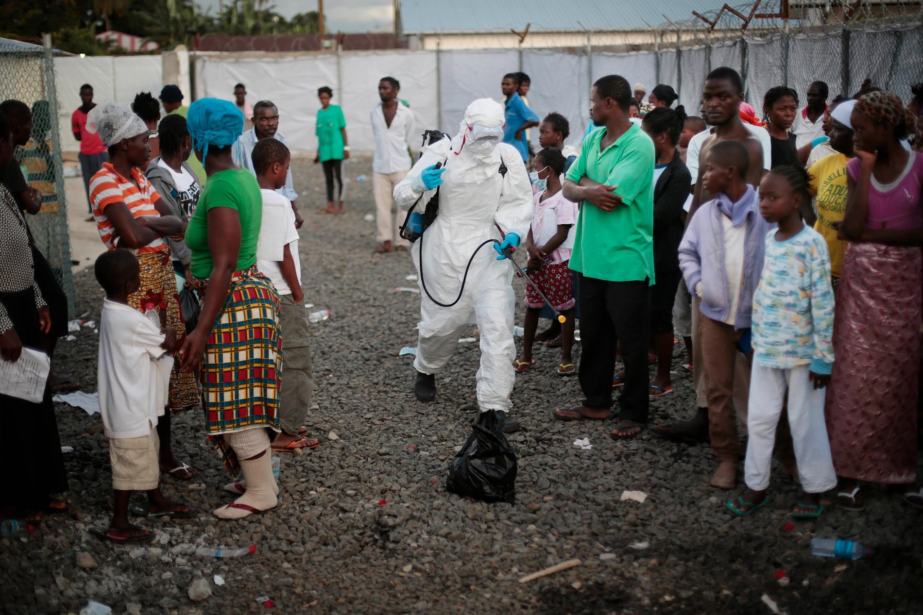 Sjukhuspersonal sprejar patienter som lämnar en ebolaklinik i Monrovia, Liberia under ebolautbrottet i Västafrika 2014. Arkivbild.