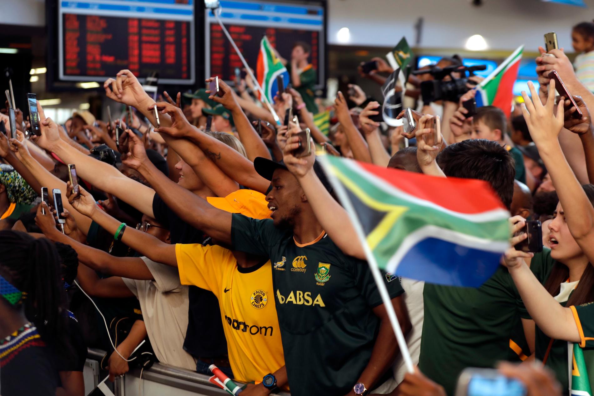 Det rådde karnevalsstämning på OR Tambo internationella flygplats i Johannesburg när de nyblivna världsmästarna Rugby kom hem till Sydafrika.