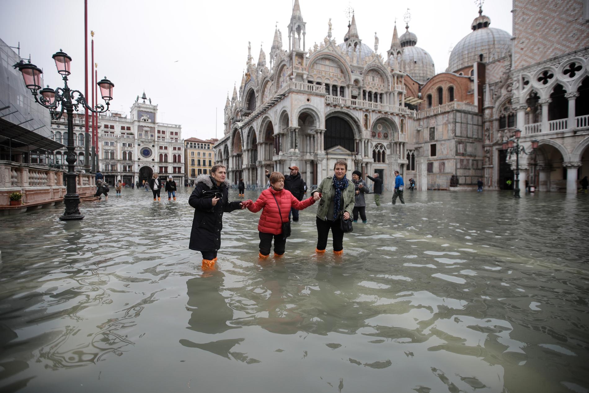 Människor vadar i vattnet på översvämmade Markusplatsen i Venedig.