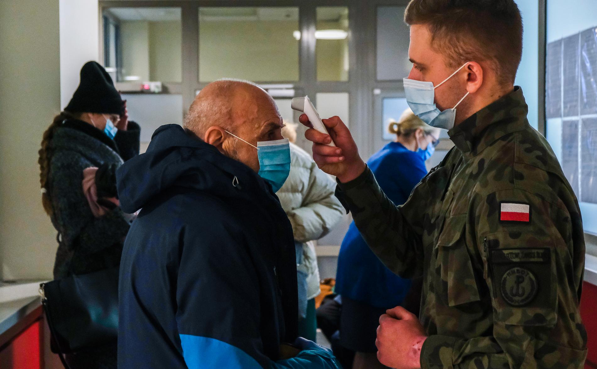 På Krakows universitetssjukhus är militären inkallad för att hjälpa till. Här undersöks en äldre man som ska vaccineras. 