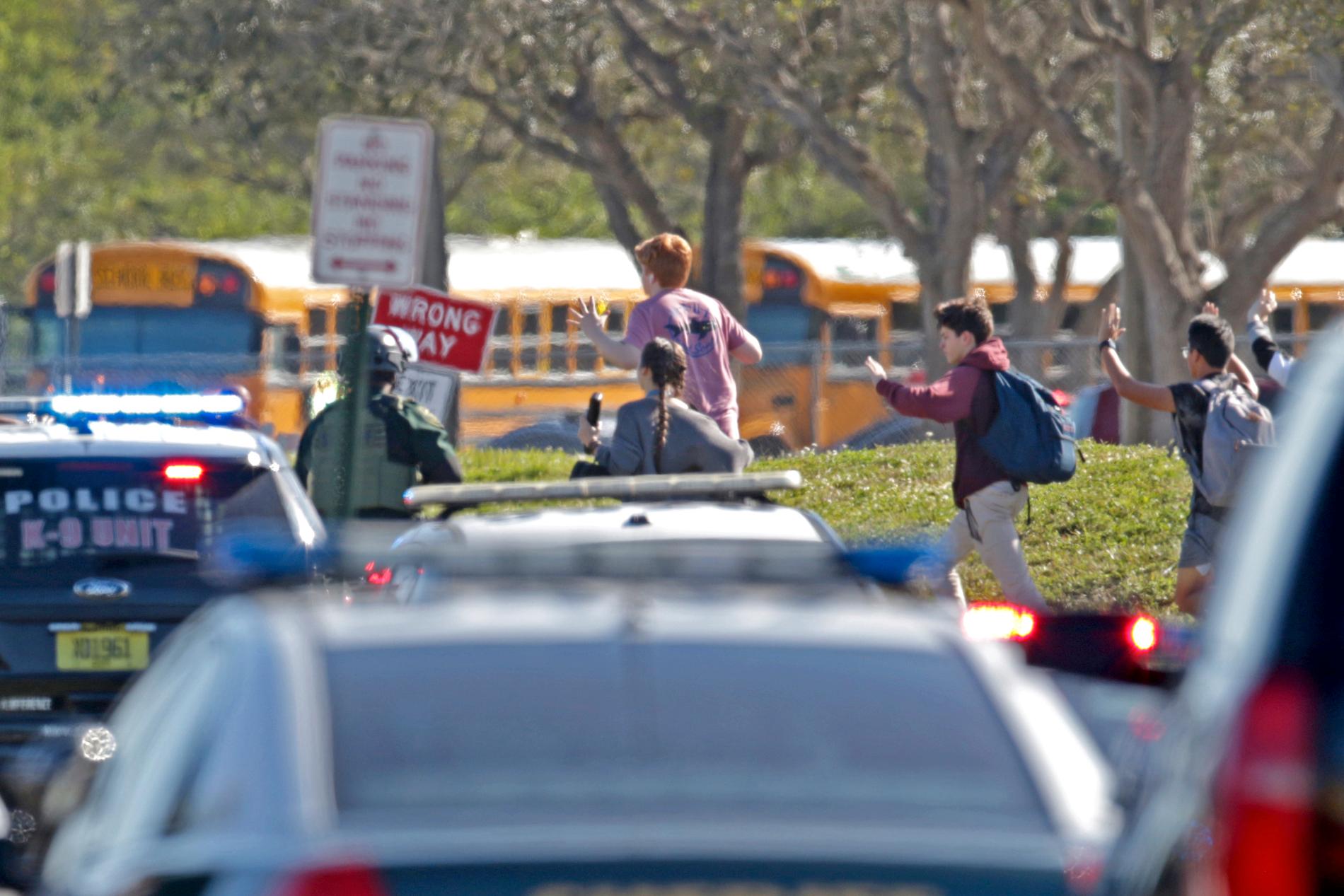 Studenter med händerna i luften springer från Marjory Stoneman Douglas High School i Parkland i Florida i onsdags. 17 personer dödades i masskjutningen.