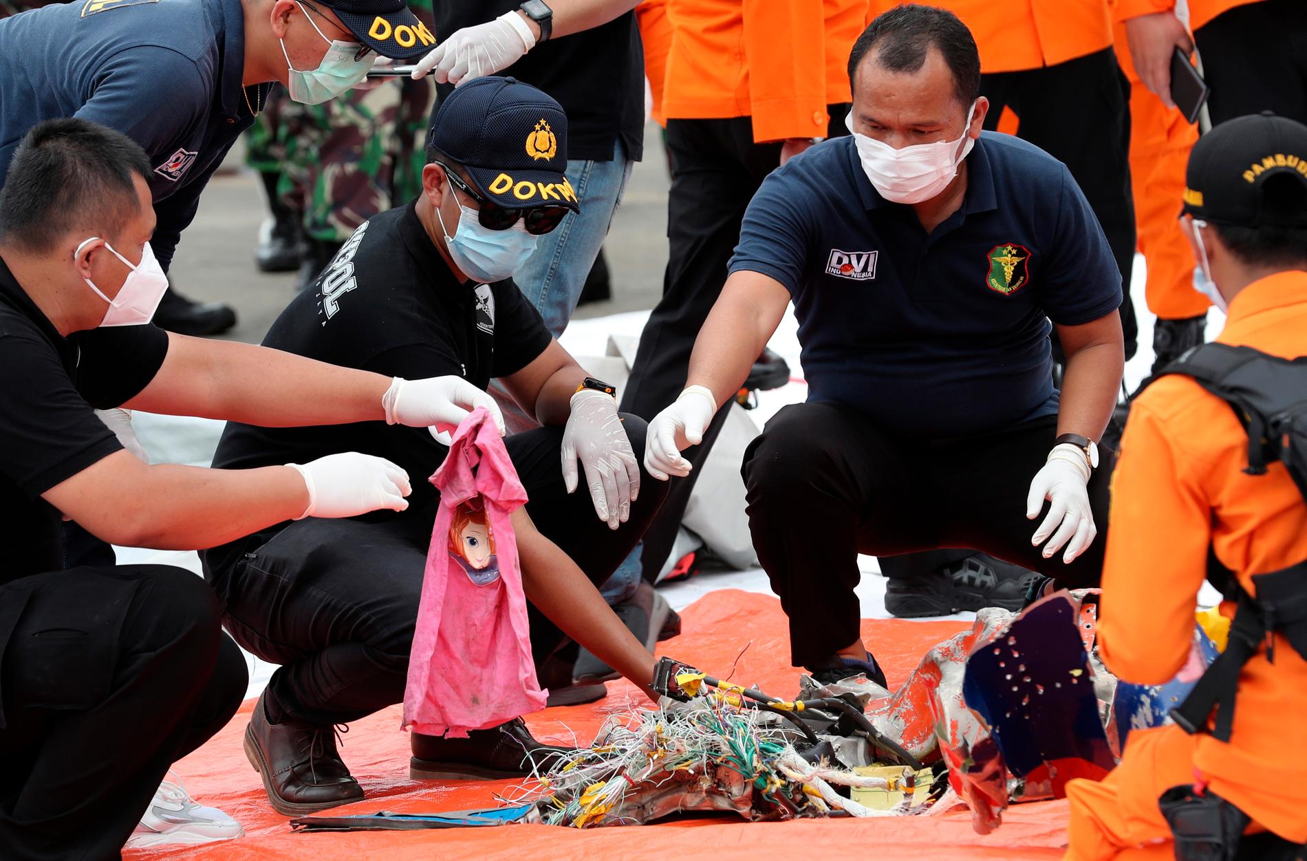 Haveriutredare går igenom fynd som hittats i vattnet utanför Jakarta i Indonesien där det försvunna passagerarplanet tros ha kraschat.