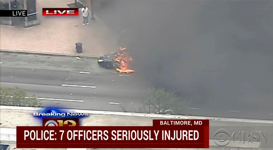 Livebilder visar hur en polisbil satts i brand.