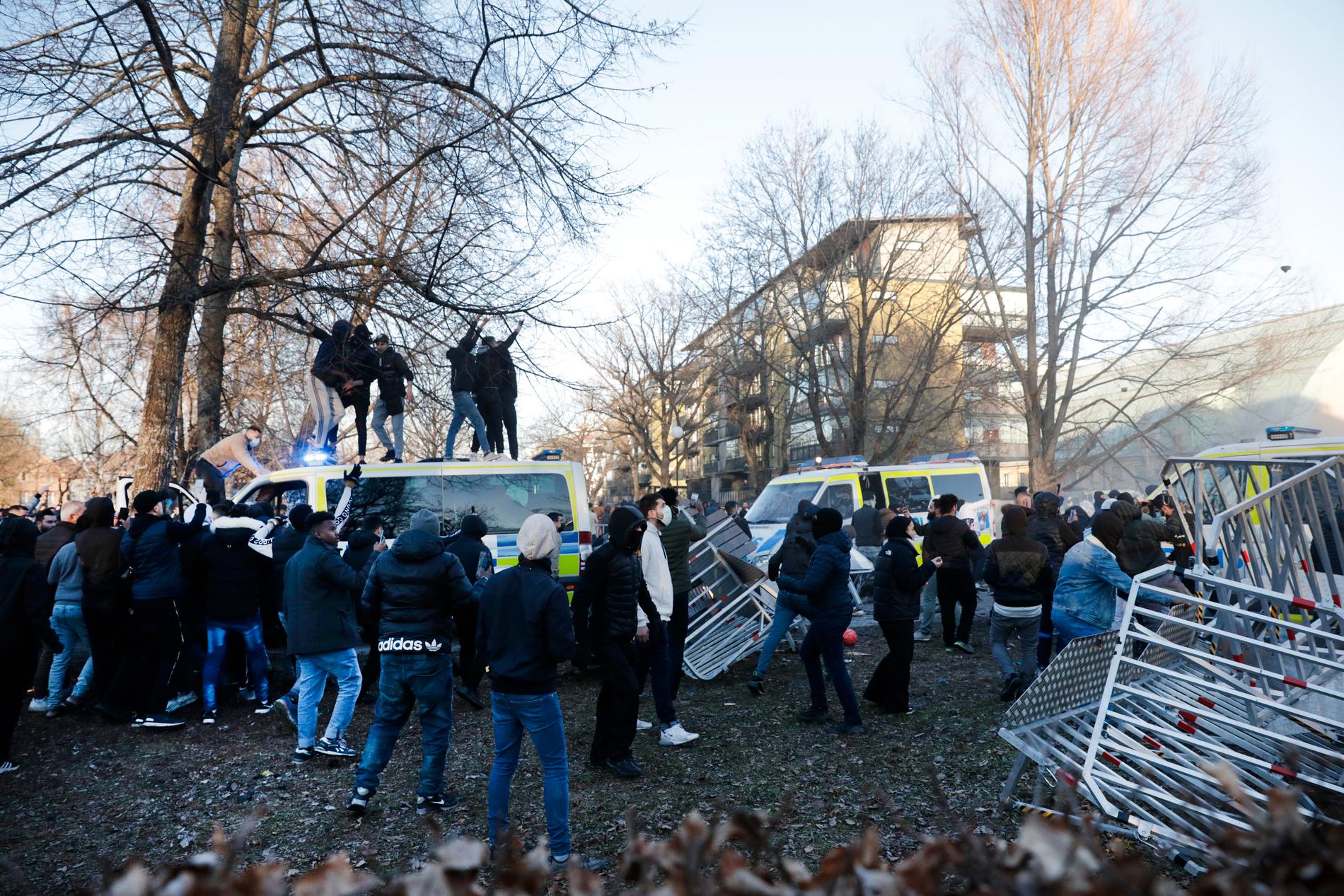 Personer klättrar upp på en polisbuss i Sveaparken i Örebro, där Rasmus Paludan talade på långfredagen. 