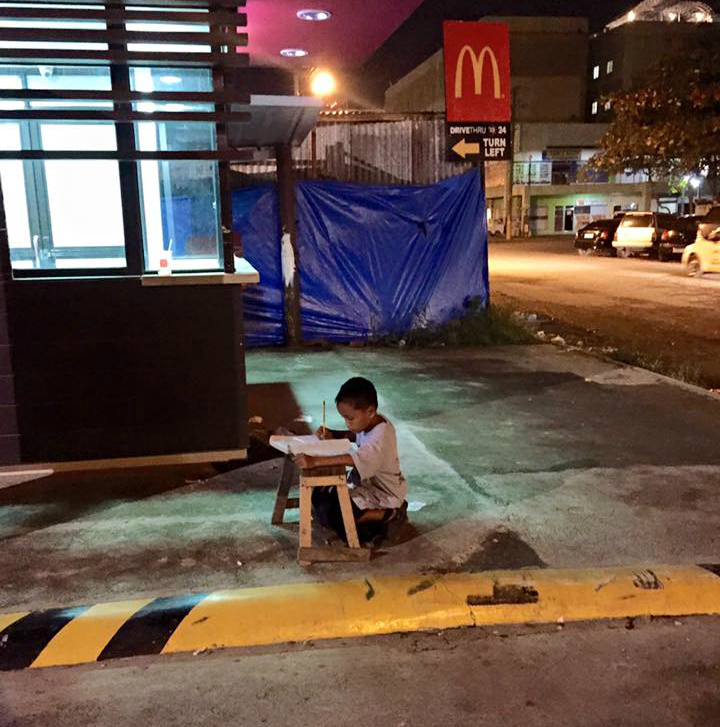 Bilden på pojken som gör sin läxa på trottoren har berört tusentals. Foto: Joyce Torrefranca