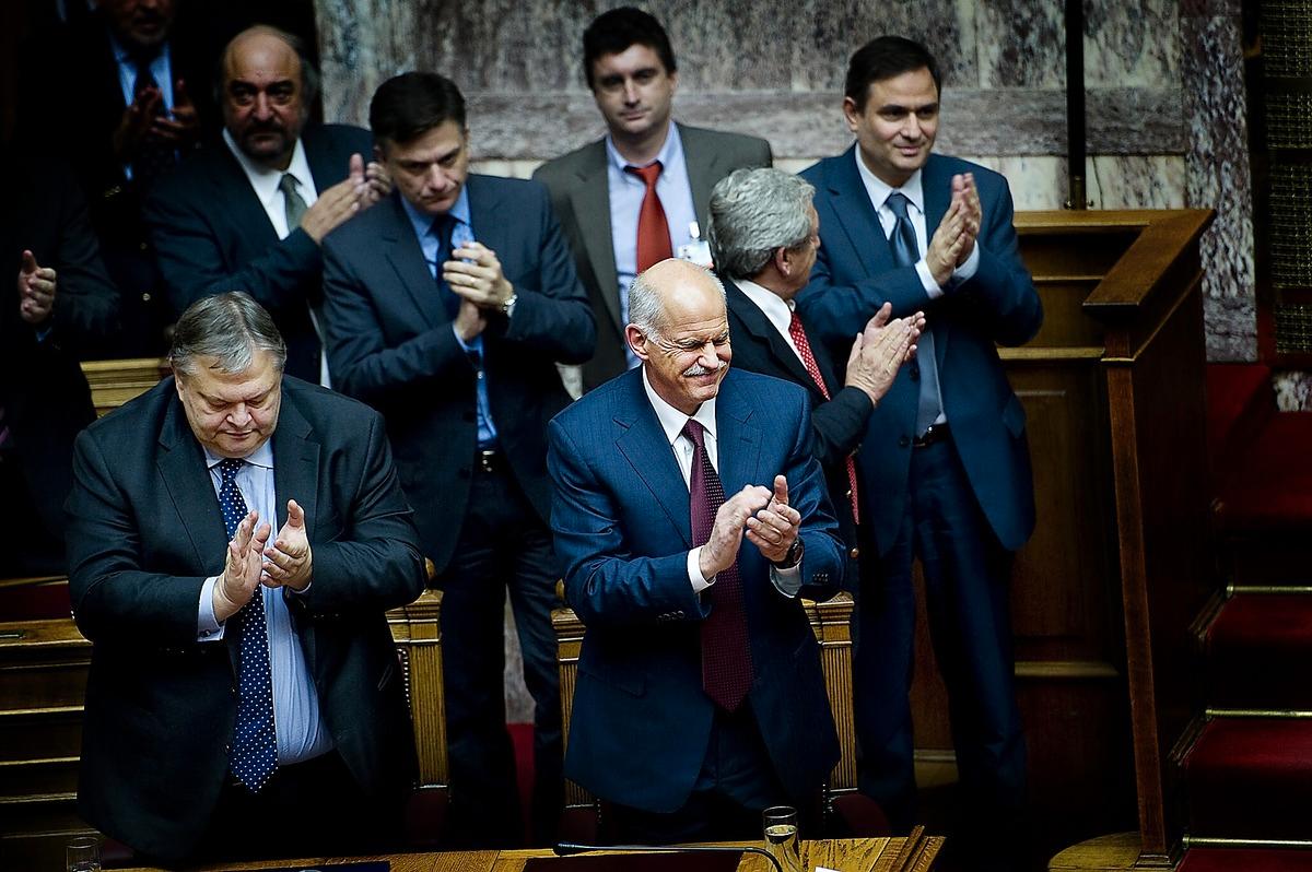 En lättad Papandreou applåderar resultatet av omröstningen.