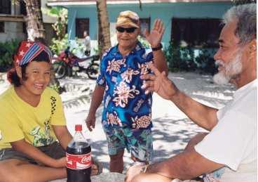 Falefaea Tapu (i blå skjorta) och hans vänner söker skugga på torget. Här går livet i ett lugnt tempo och tuvaluanerna är kända för att vara vänliga och hjälpsamma.