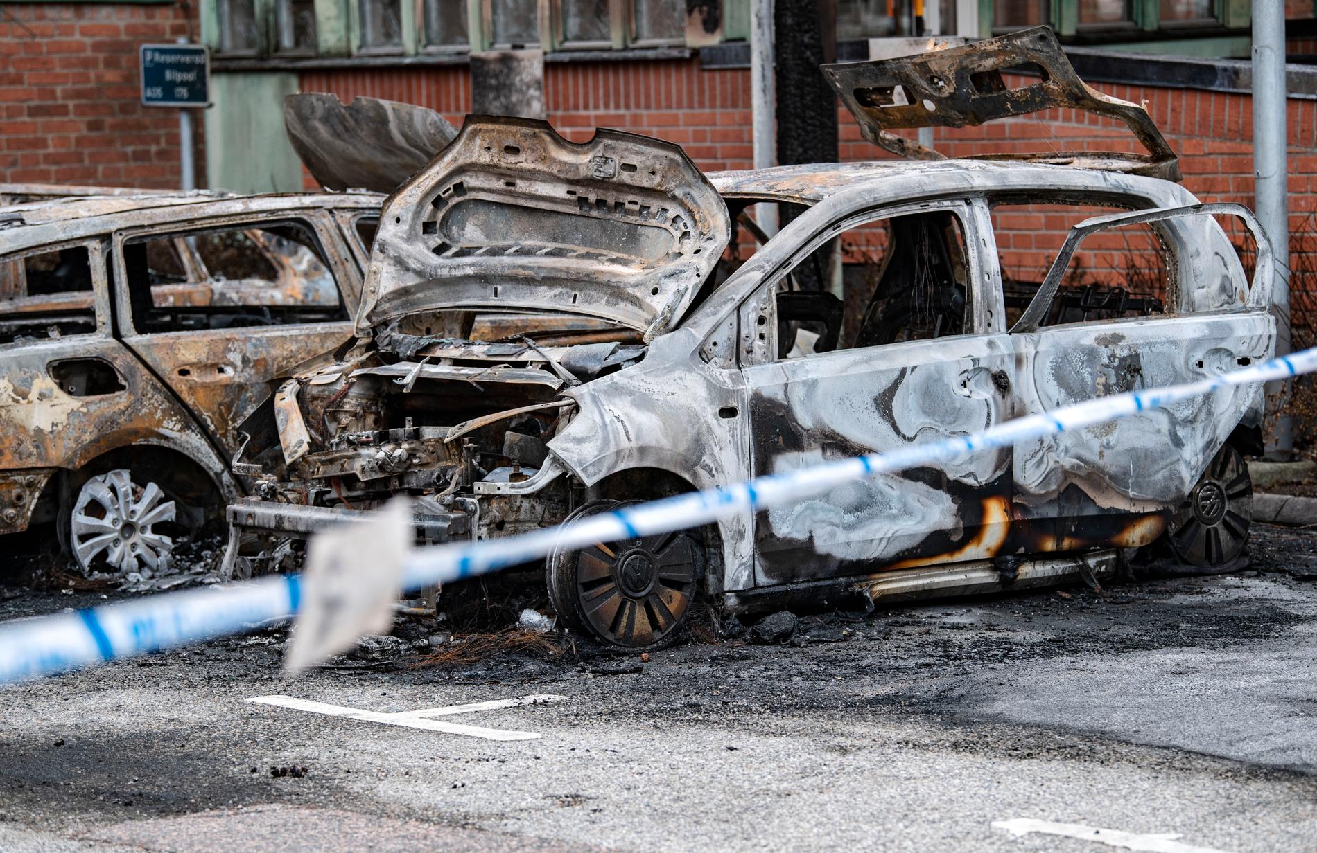 Tre utbrända bilar bakom polisens avspärrningar vid Region Skånes lokaler i september. 