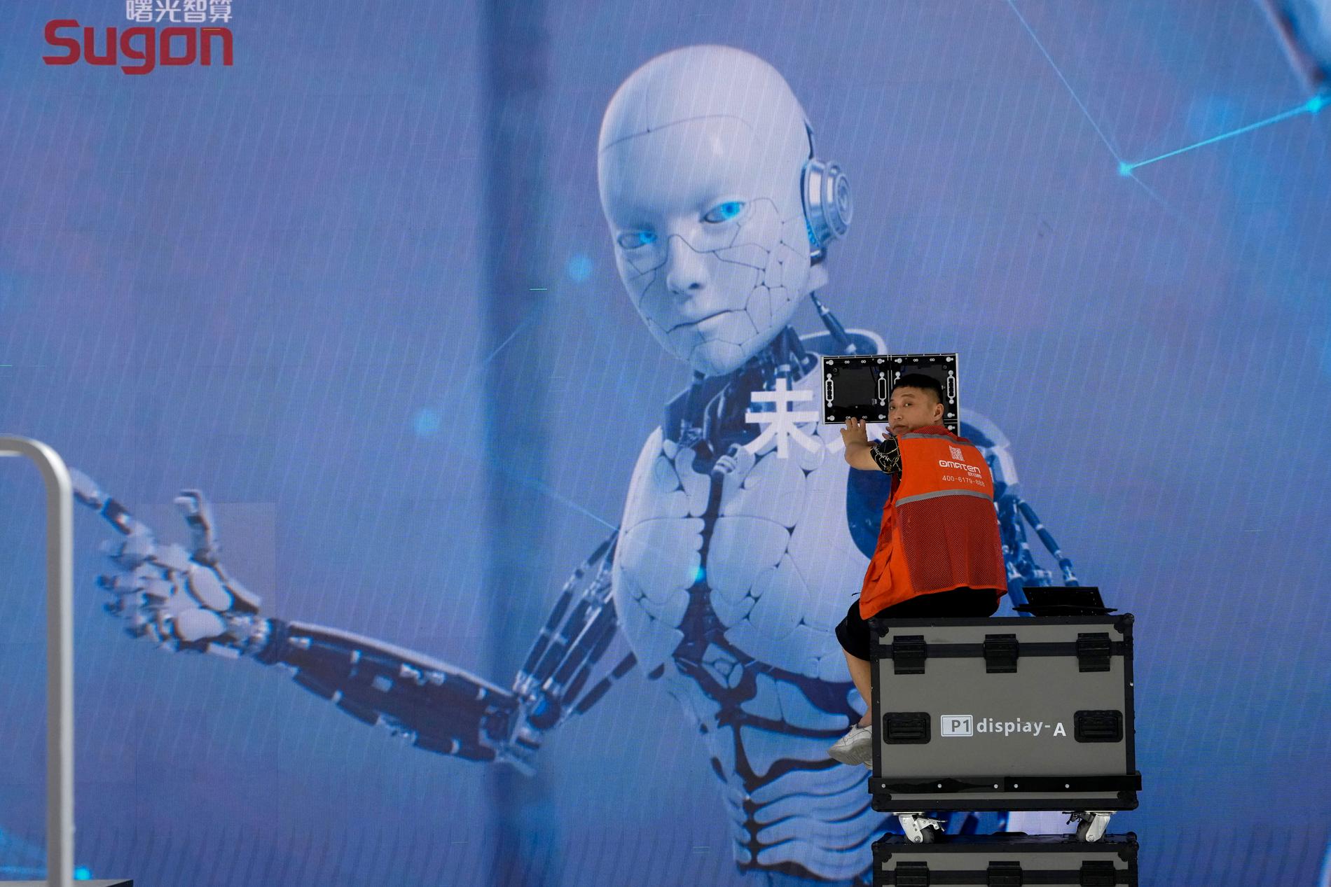 En (mänsklig) arbetare jobbar med storbildsskärmen på World Artificial Intelligence Conference i Shanghai i juli i år 