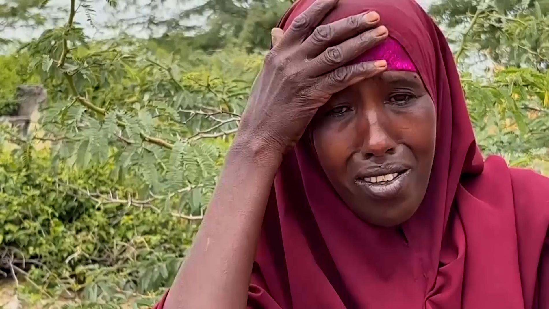 Fadumo Abdi Aliyow sitter vid sina söners grav, utanför lägret i Mogadishu. Hon lämnade sitt hem tillsammans med sönerna för att söka hjälp, men båda hann dö av svält och infektioner. 