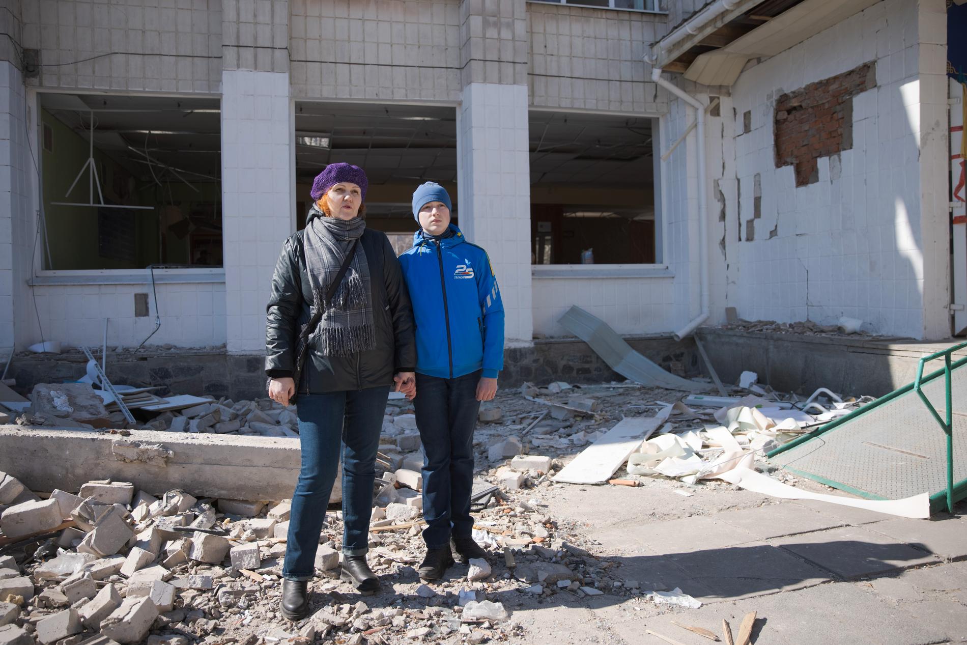 Svetlana Yaropovets, 44, med sin son Yevgienij, 14, utanför skolan som blev bombad. Svetlana har själv varit elev i skolan. 