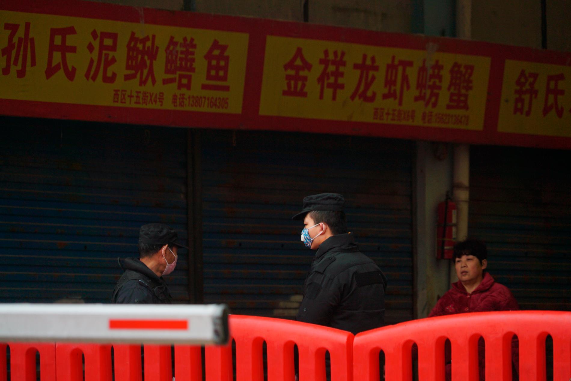 Polis på plats utanför den marknad i storstaden Wuhan där tidiga fall av coronasmittade befunnit sig. Arkivbild.