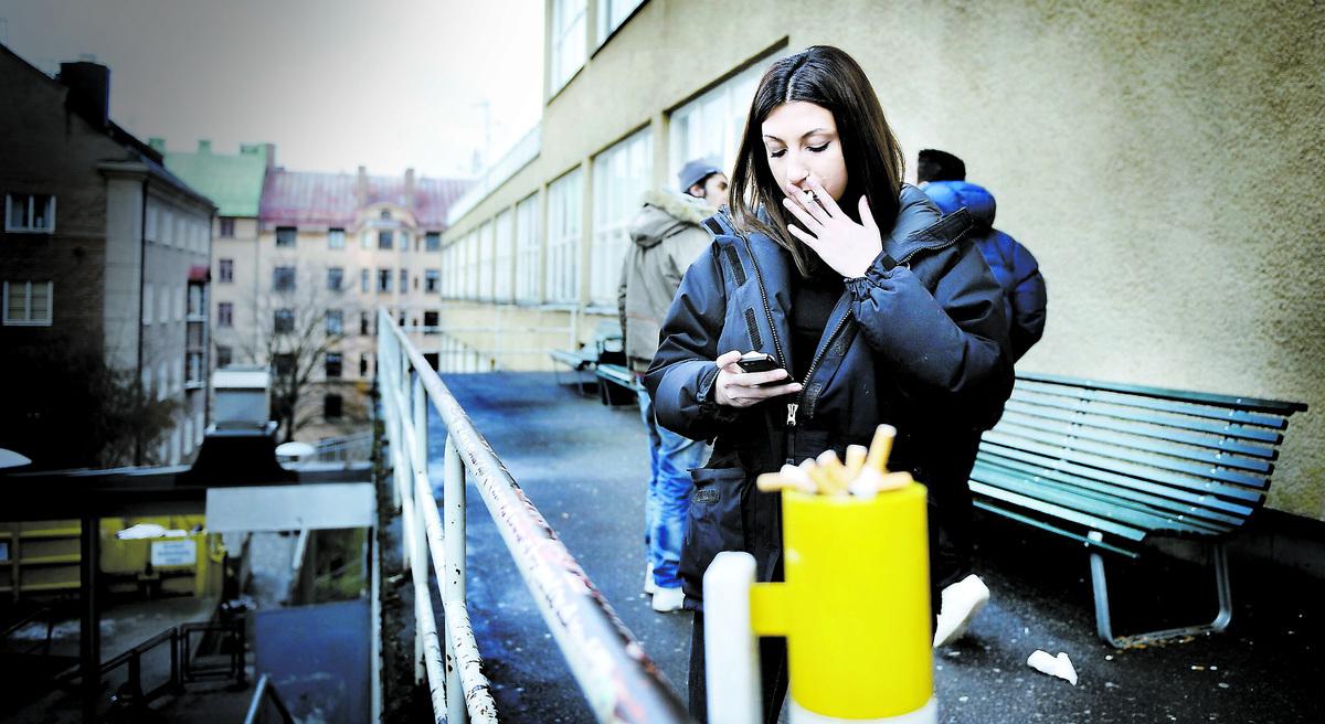 Jasmine tänder en cigg utanför dörren till matsalen på Sankt Eriks gymnasium. I rökrutan som officiellt inte finns. Att röka på skolgården förbjöds 1994 – men de flesta gymnasieelever kan blossa lugnt.