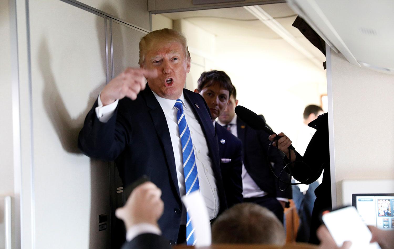 Trump pratar med reportrar ombord på flygplanet Air force one.