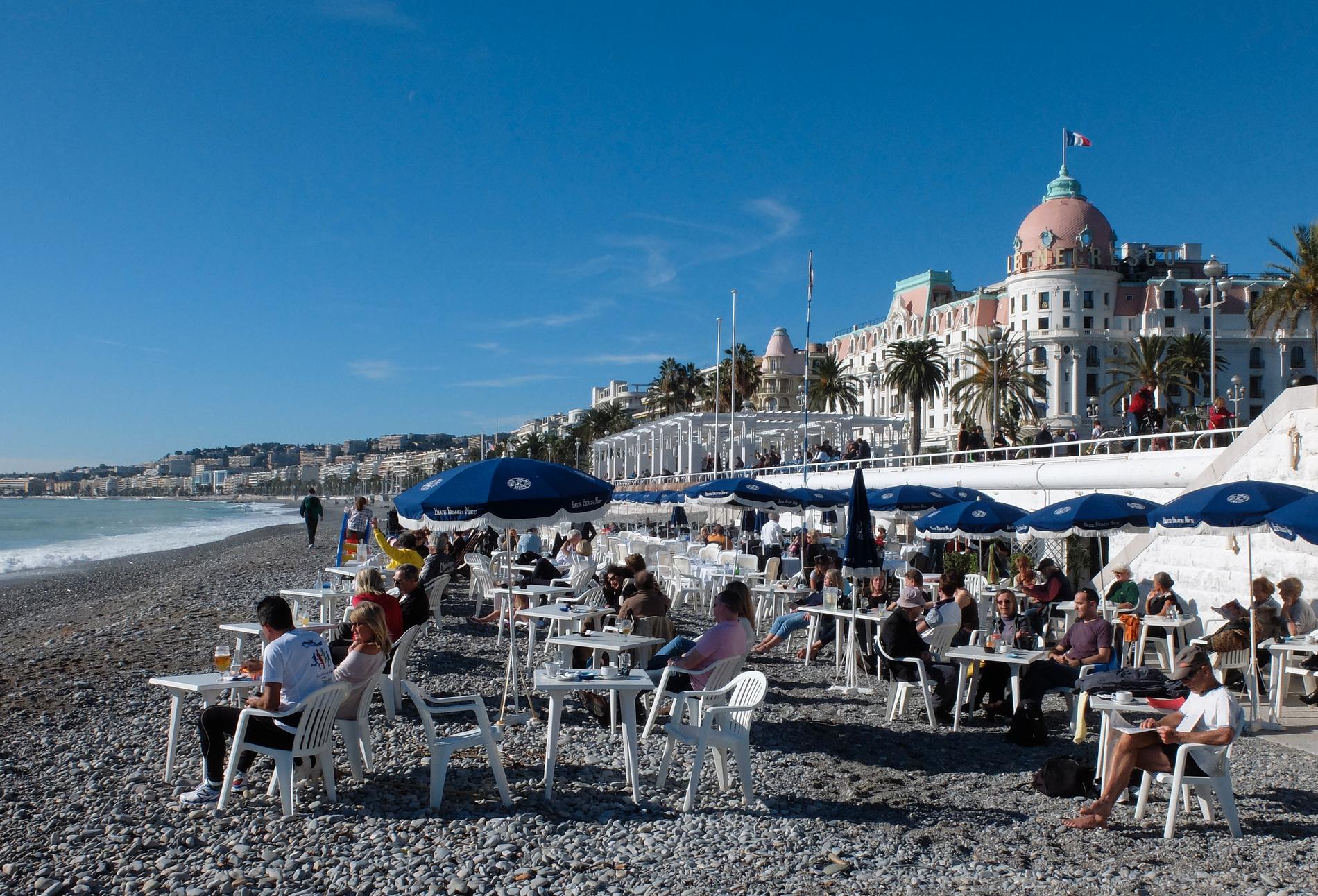 Människor njuter av solen på stranden i Nice på den franska rivieran. Arkivbild.