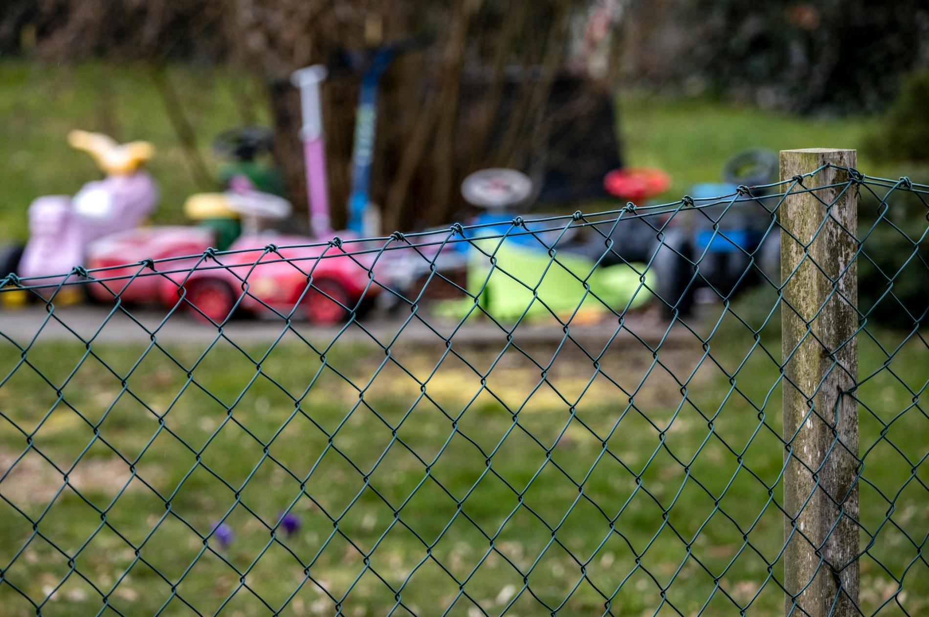Leksaker bakom staketet i flickans trädgård. 