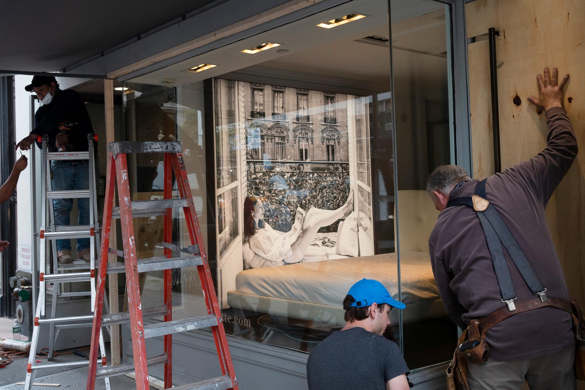 Plywood sätts för fönstren på en butik på Madison avenue för att skydda från plundring.