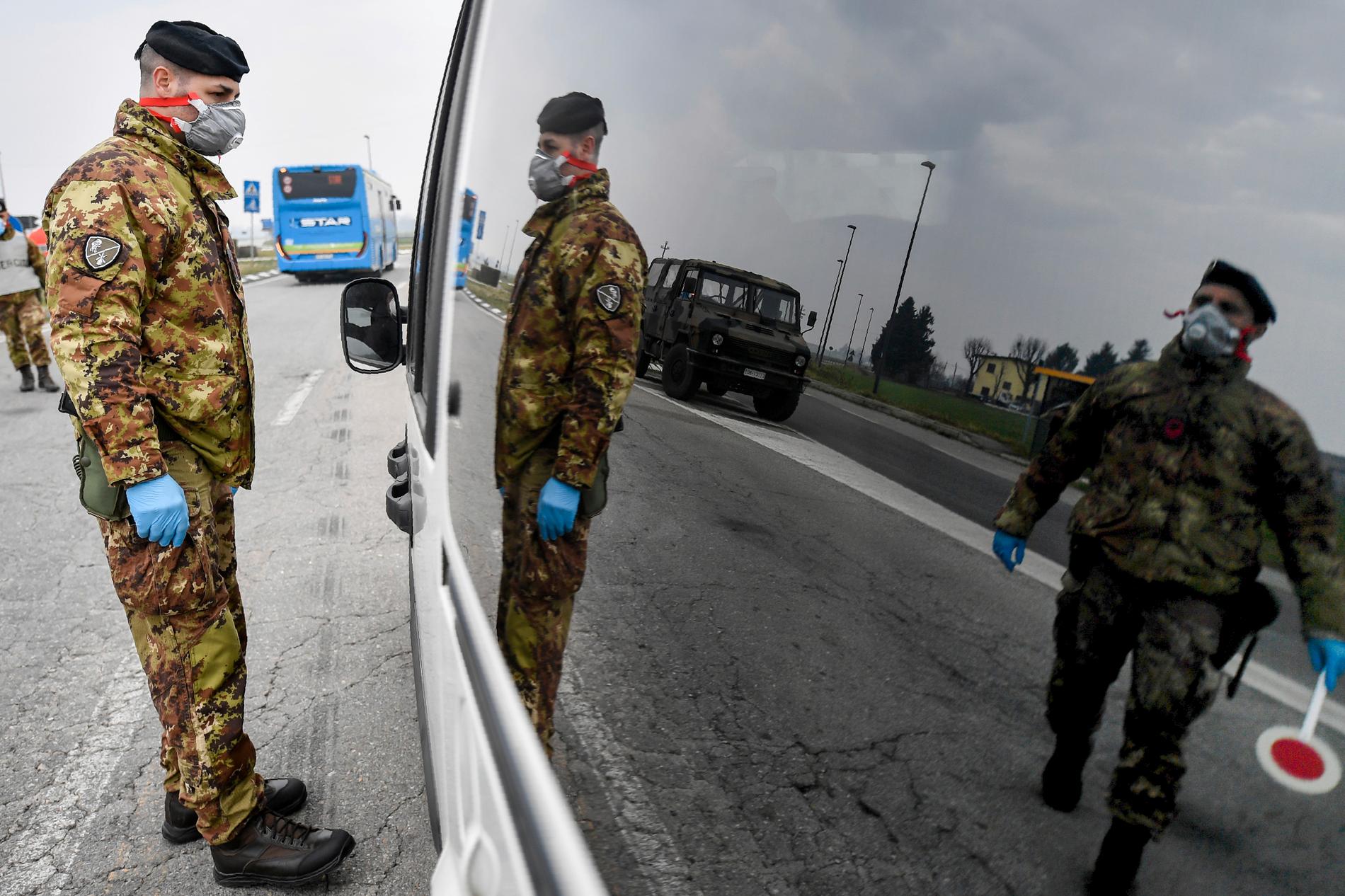 Italienska soldater kontrollerar fordon som vill passera vid de isolerade områdena i norra Italien.
