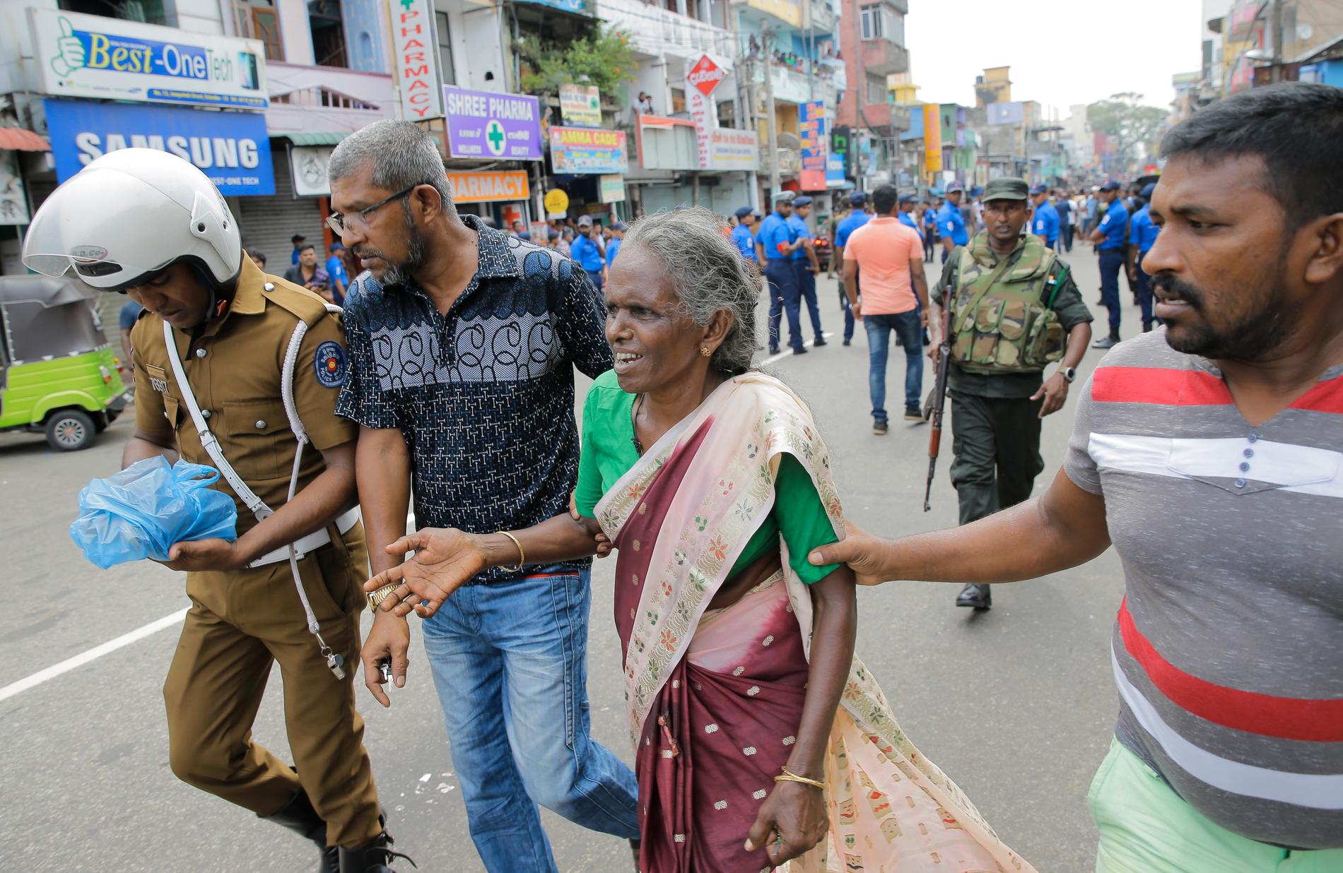 Äldre kvinnor får hjälp efter explosionen i en av kyrkorna i Colombo.