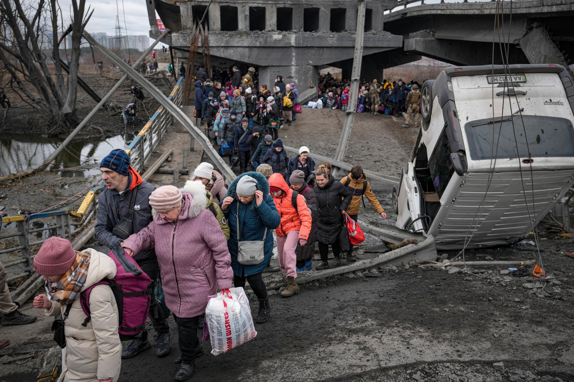 Civilpersoner går över en förstörd bro i Irpin, Ukraina, 5 mars.