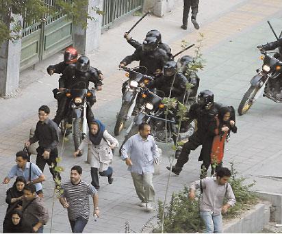 Brutalt Säkerhetsstyrkor slår anhängare till Mousavi under upploppen i Teheran i går.