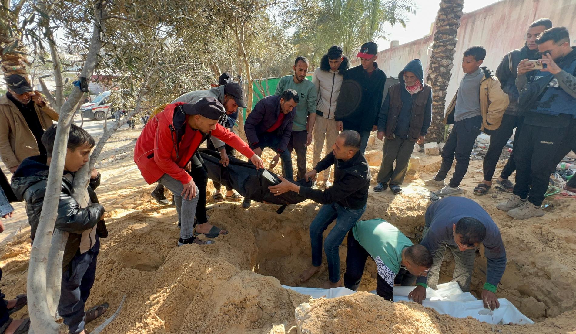 Palestiniers kroppar begravs på mark som tillhör Nassersjukhuset i Khan Yunis på måndagen.