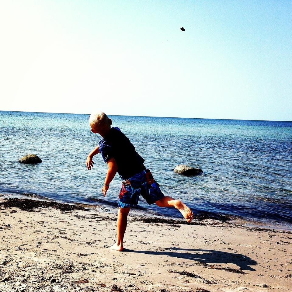 Min son Abbe kastar sten på stranden i Kämpinge