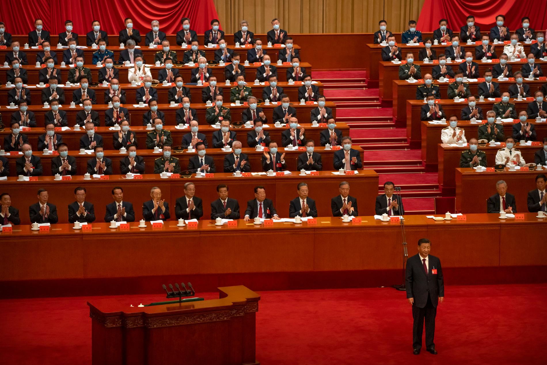 Handplockade delegater i Folkets stora sal i Peking applåderar president Xi Jinping under partikongressens första dag den 16 oktober.
