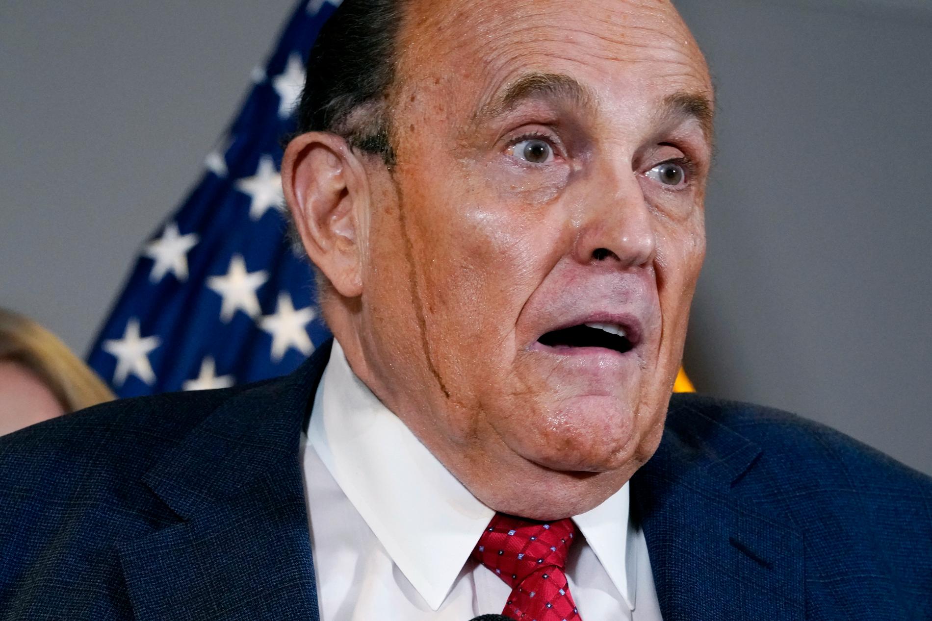 Rudy Giuliani med svart färg rinnande över ansiktet vid en presskonferens i november 2020.