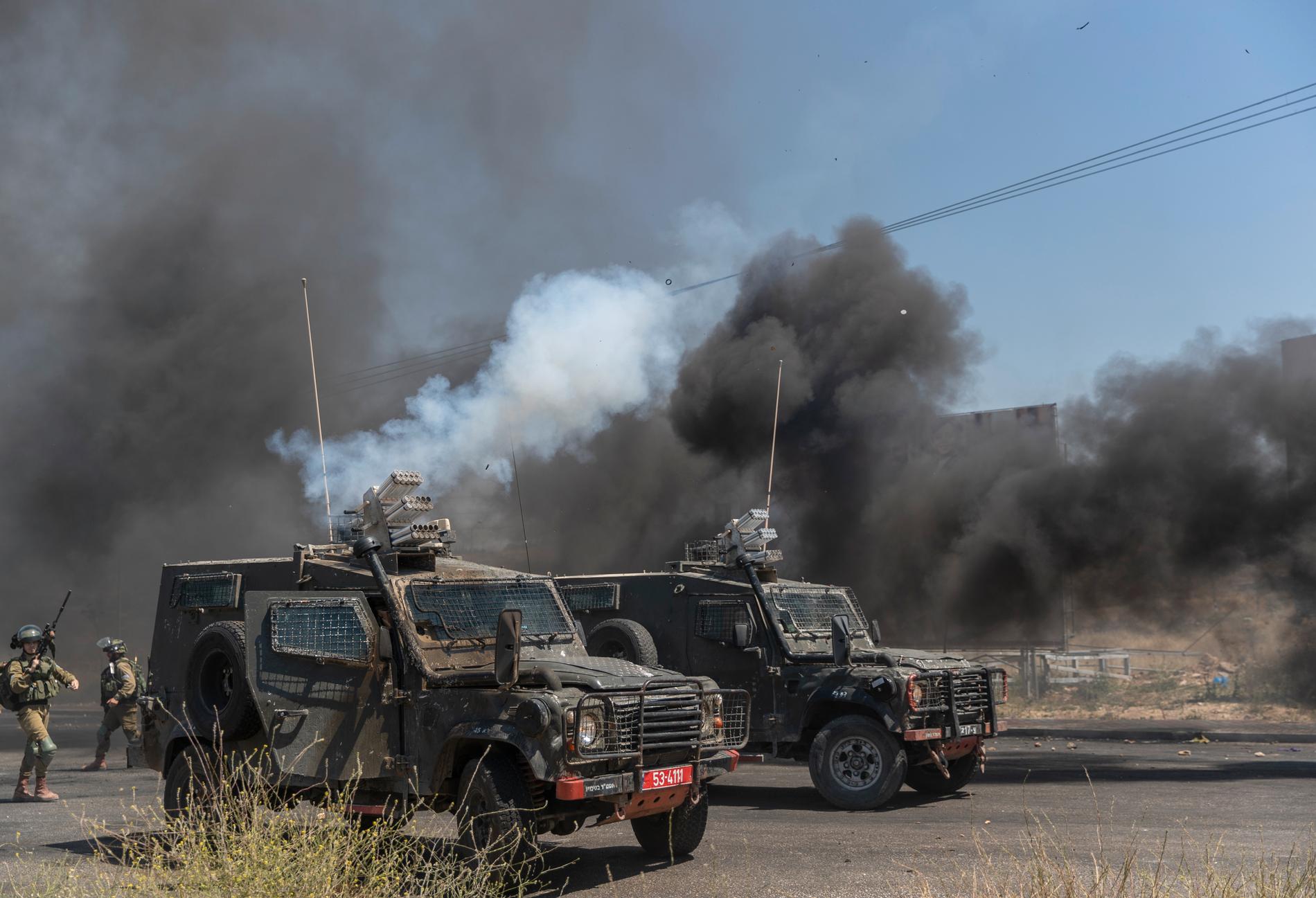 Israeliska militärfordon avfyrar tårgasbehållare mot palestinska demonstranter utanför Ramallah på Västbanken.