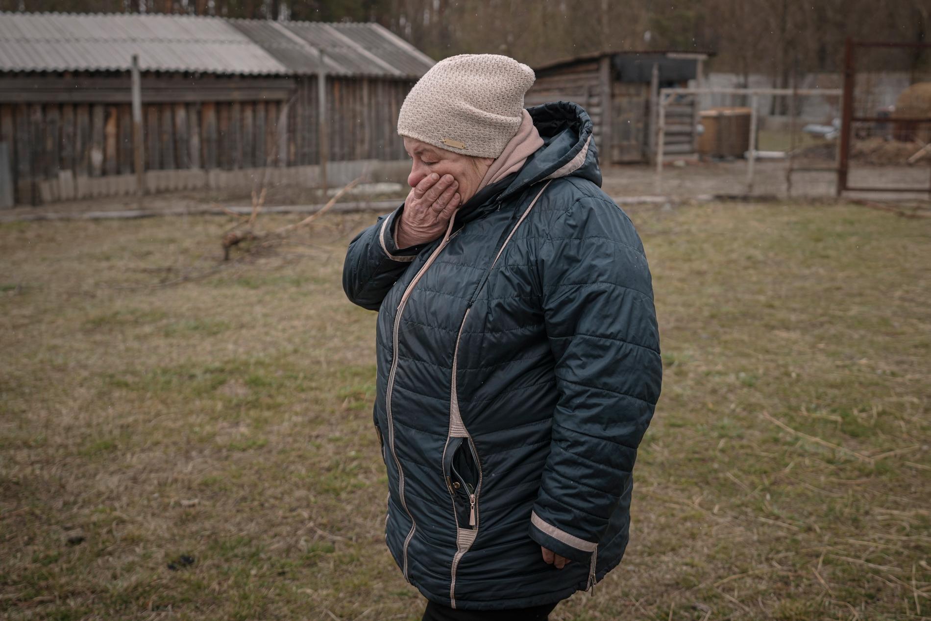 En kvinna tar sig för ansiktet efter att ha identifierat sin man som hittats död efter att ryssarna lämnat Motyzhyn. 