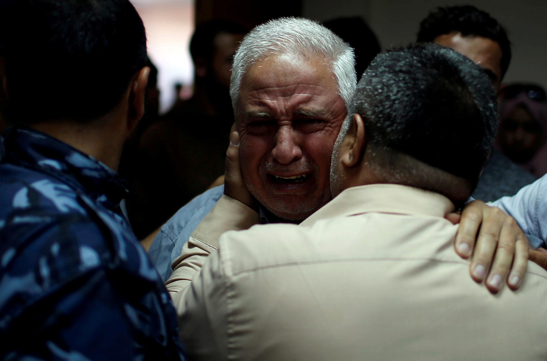 En släkting till en palestinsk man som dog i protesterna tröstas på sjukhus i Gaza.