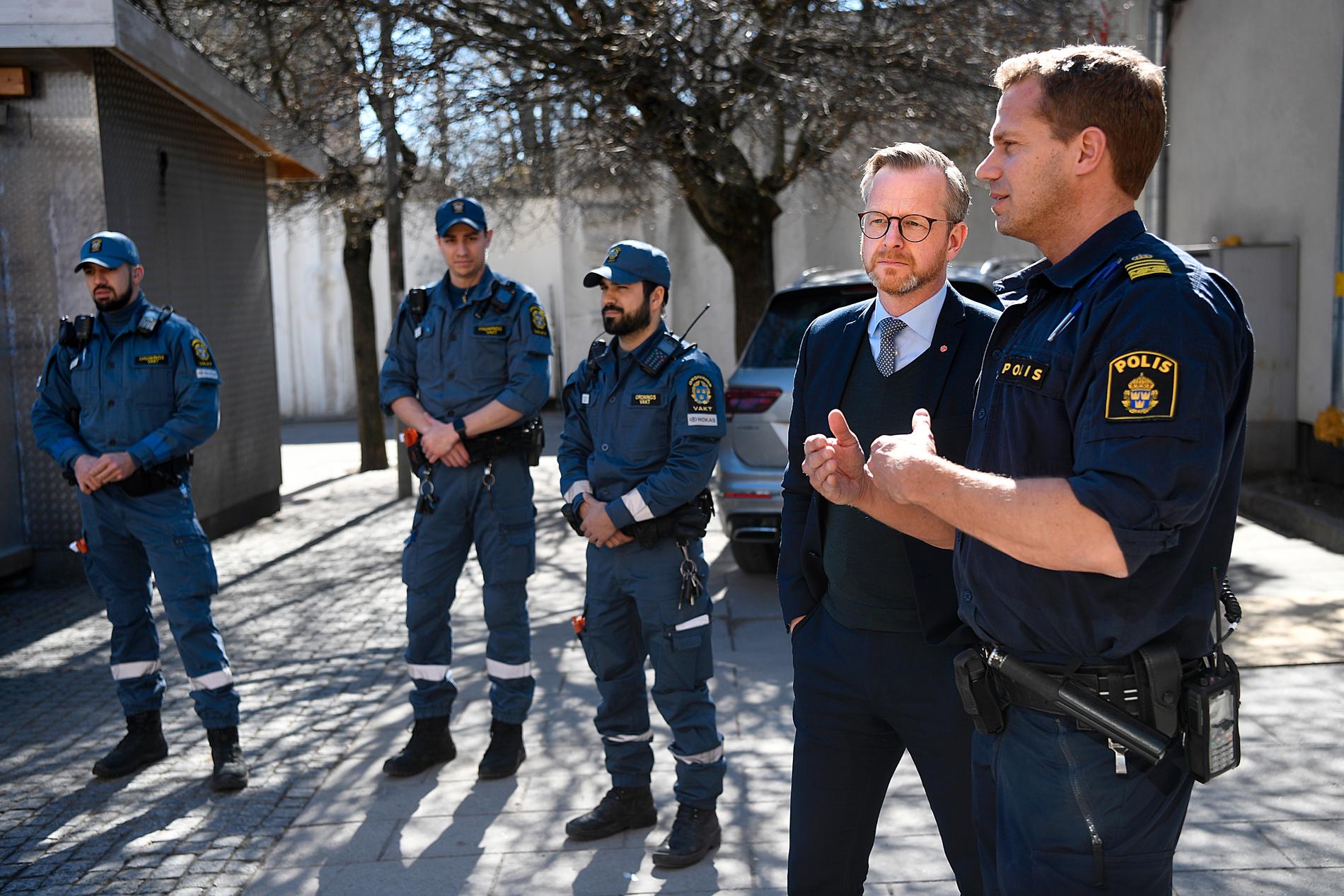 Mikael Damberg talar med en polis i Särta centrum. 