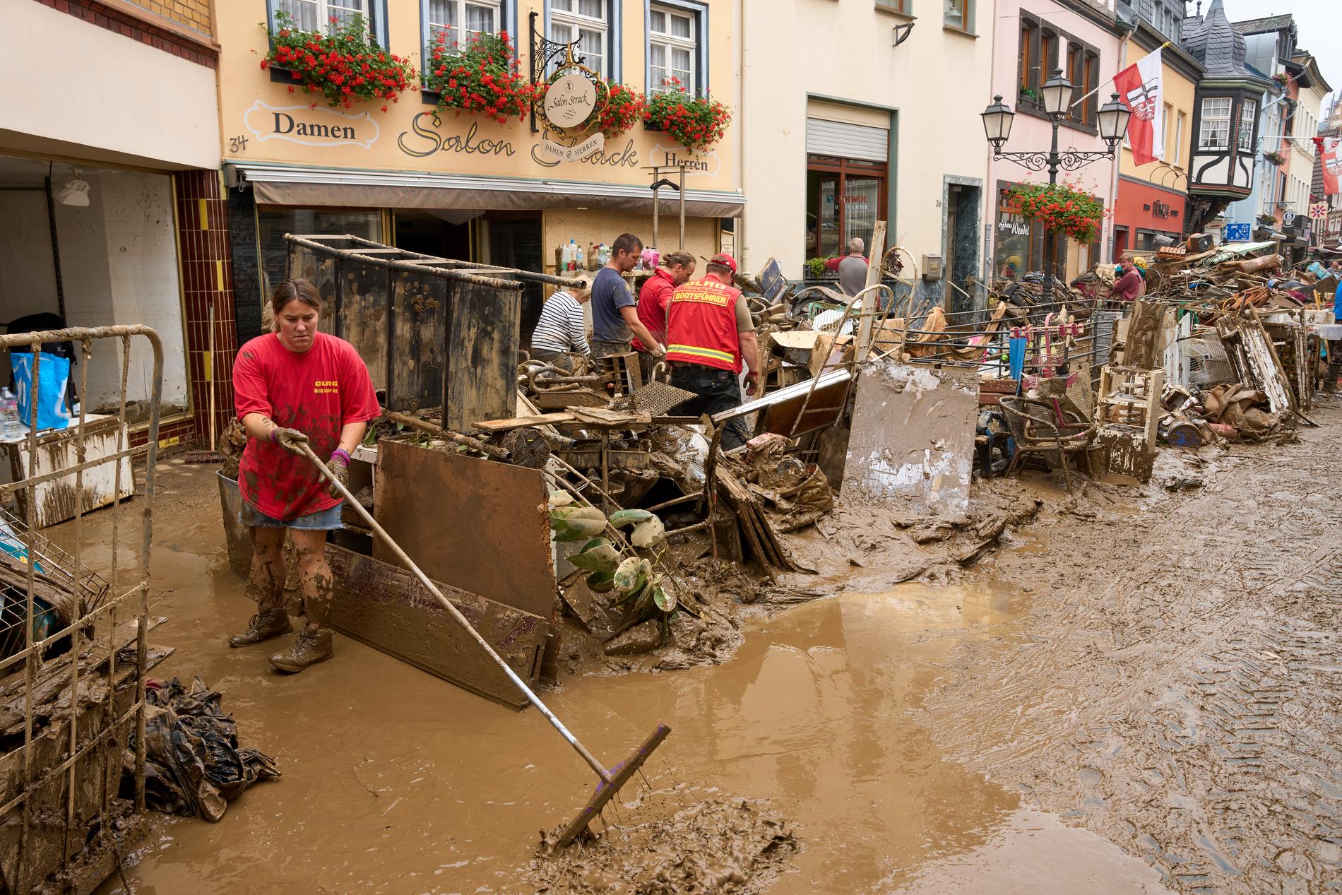 Boende i tyska Ahrweiler städar upp efter en översvämning i juli. 