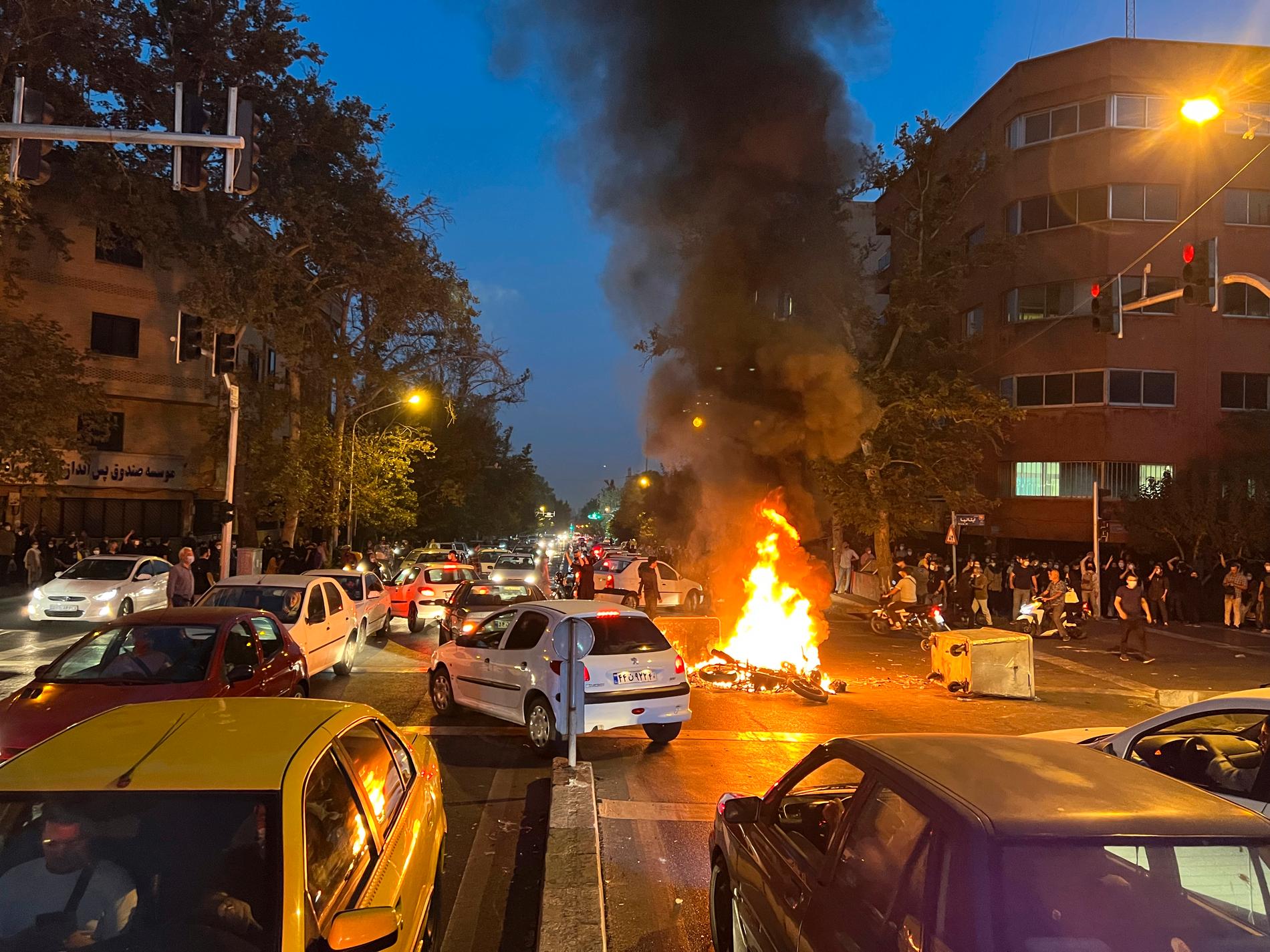 Polismotorcykel brinner i Teheran, Iran, under protester på måndagskvällen.