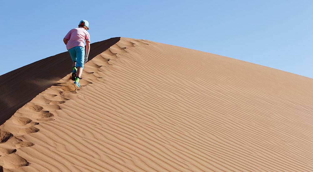 Kalle klättrar upp för en sanddyn i Namibia. 