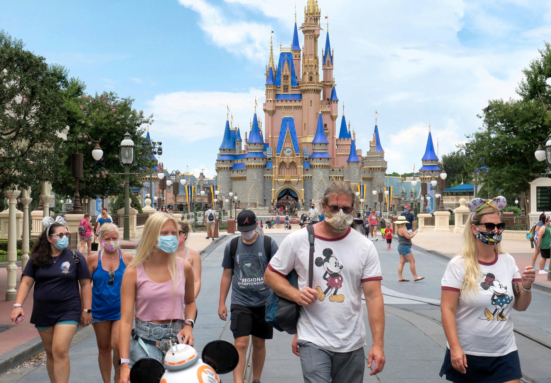 Gäster med masker på nöjesparken Disney World i Florida när parken återöppnade i helgen.