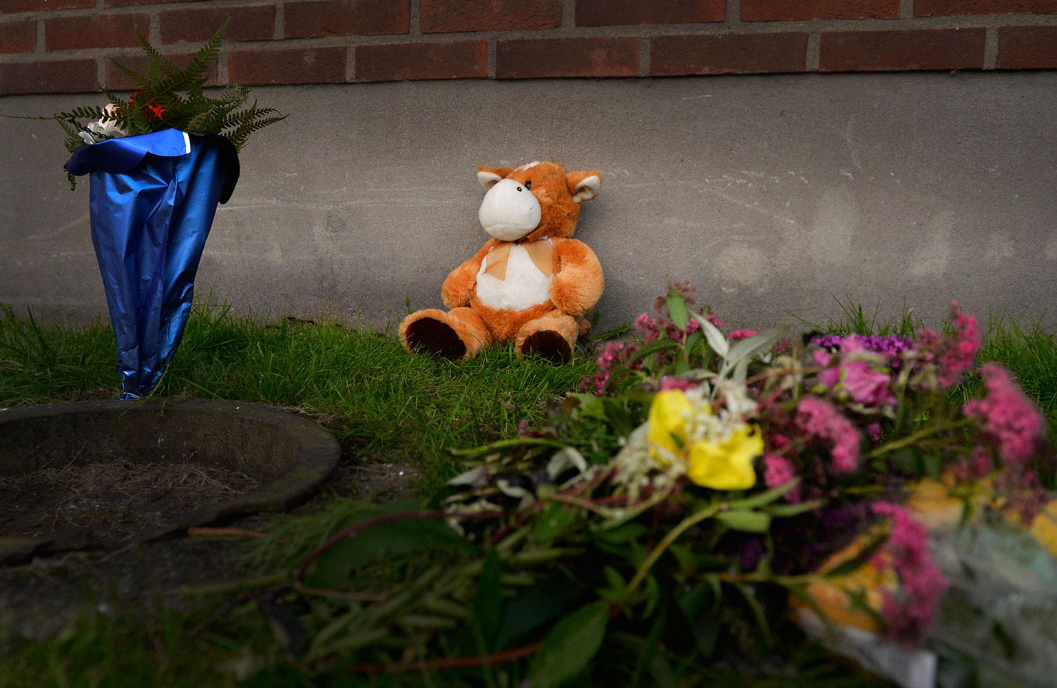 Blommor och nallar har lämnats av sörjande och boende utanför lägenheten där pojken dog.