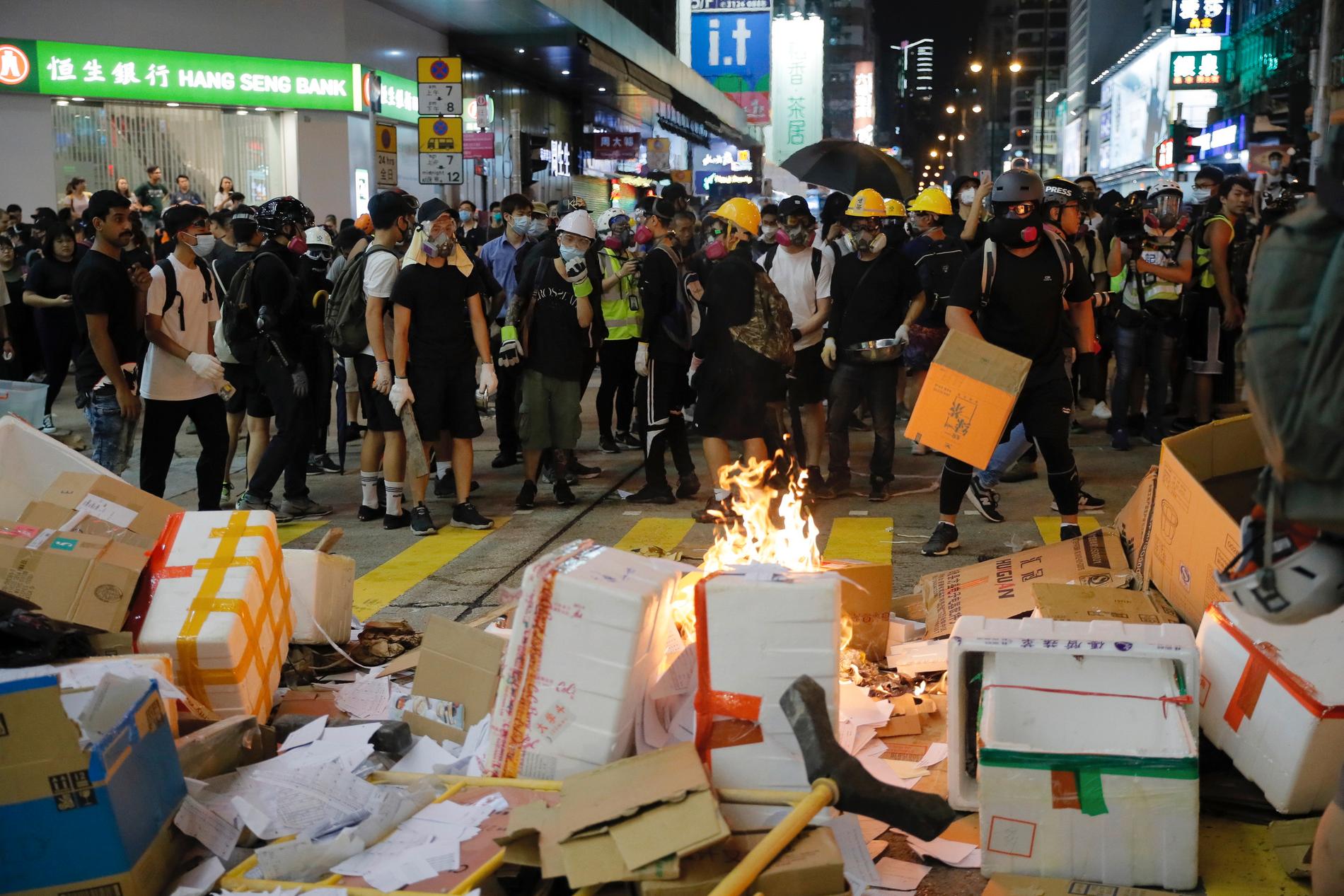 Aktivister vid brinnande pappkartonger under protesterna i Hongkong på fredagskvällen.