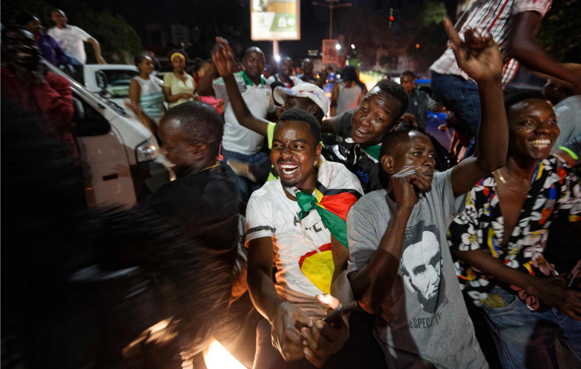Dansande och sjungande invånare firade under natten Mugabes avgång i huvudstaden Harare.