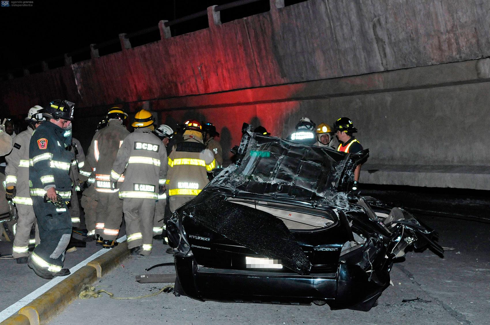 Räddningsarbetare vid en förstörd bil efter att en bro kollapsat under jordbävningen.