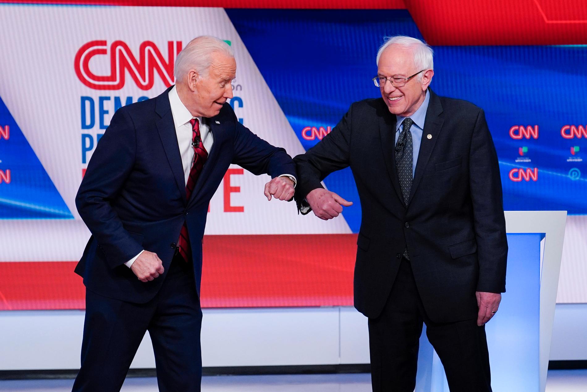 Den tidigare vicepresidenten Joe Biden och Vermontsenatorn Bernie Sanders, båda demokrater, gör en "virushälsning" före en tv-debatt i mars.