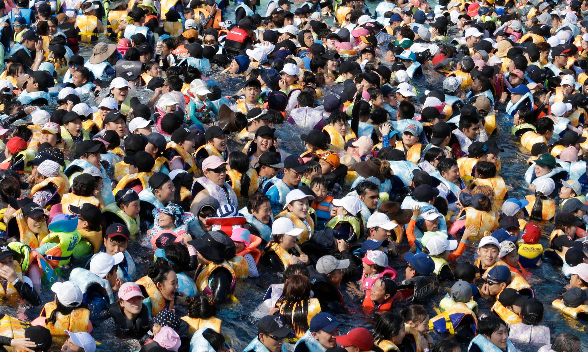 Folkmassa som försöker undvika värmen i en stor swimmingpool kallad ”Caribbean Bay” i Yongin, Sydkorea, torsdagen den 2 augusti 2018. 