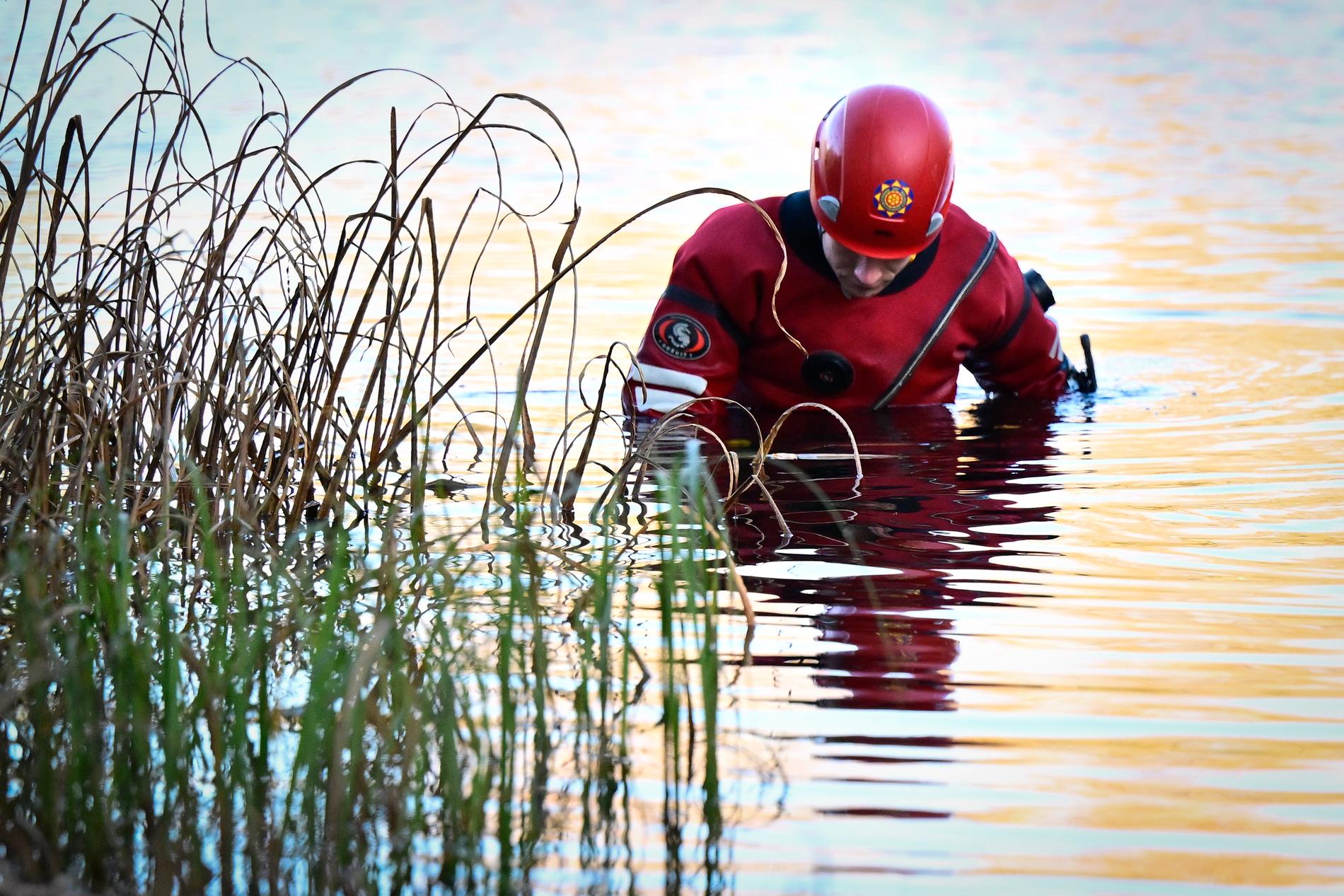 Personal från räddningstjänsten söker i vattnet.